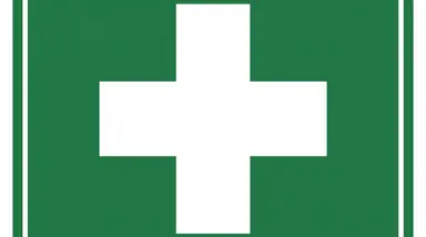 First aid sign with white cross on green background