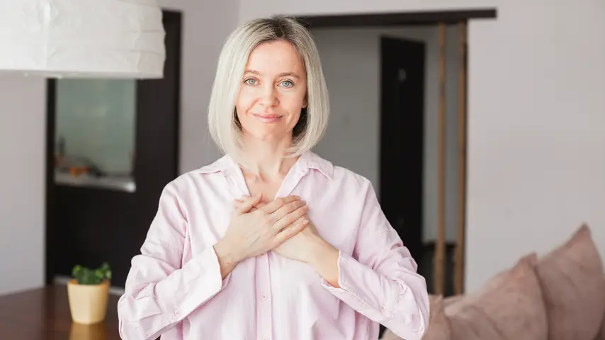 A smiling women with her hands placed over her heart